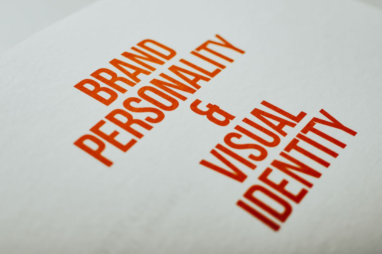 services-02 Close-up of Brand Personality & Visual Identity text in red on white paper.